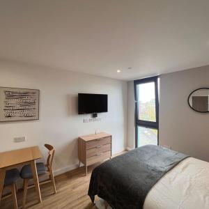 Dormitorio con cama, escritorio y TV en Aberdeen by Charles Hope en Aberdeen