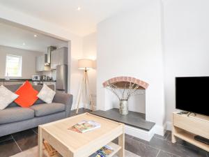 a living room with a couch and a tv at 1 Millbank in Keswick