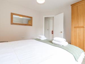a bedroom with a large white bed with towels on it at 1 Millbank in Keswick