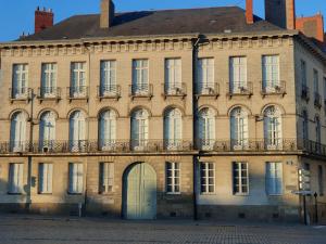 - un grand bâtiment en briques avec une porte devant dans l'établissement Le 1825, une suite luxueuse au coeur de la ville, à Nantes