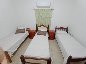 een groep van drie bedden in een kamer bij el mistol in San Miguel de Tucumán