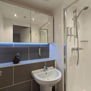 a bathroom with a sink and a shower with a mirror at Aberdeen by Charles Hope in Aberdeen