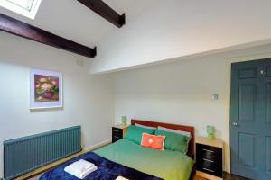 a bedroom with a green bed and a blue door at Headingley 2 Bedroom cottage flat Near Universities shops& Park in Leeds