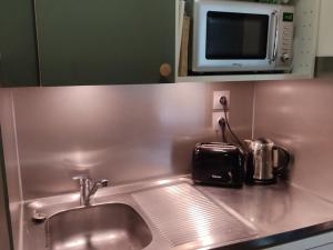 a kitchen sink with a toaster and a microwave at Studio Plagne Bellecôte, 1 pièce, 4 personnes - FR-1-181-2333 in La Plagne Tarentaise