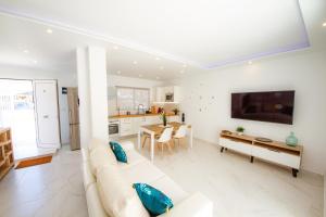 Sala de estar blanca con sofá y mesa en Green Point 3 bed holiday House, en Arona