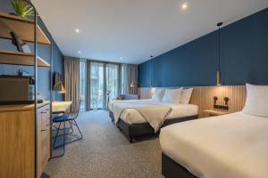 een hotelkamer met 2 bedden en een televisie bij Van der Valk hotel Den Haag Wassenaar in Wassenaar