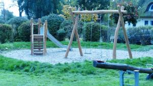 um parque infantil com uma escada e um escorrega em Komfortables Reetdachferienhaus Hasel 1 em Puddemin