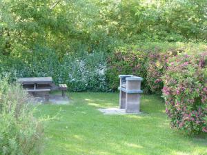 ein Park mit einer Bank und Blumen im Gras in der Unterkunft Komfortables Reetdachferienhaus Hasel 1 in Puddemin