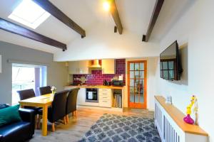 a living room with a dining room table and a kitchen at Headingley 2 Bedroom first floor cottage flat Near Universities shops& Park in Leeds
