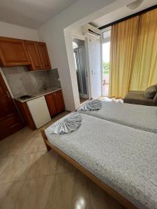 a bedroom with two beds and a kitchen with a window at Sand and Sea Apartments in Ulcinj