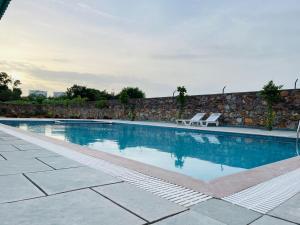 a swimming pool with two lounge chairs next to a wall at New Royal Orbit Hotel and Restaurant in Dabok