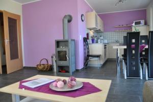 cocina con paredes de color púrpura y mesa con plato en Ferienhaus Müritzperle, en Marienfelde