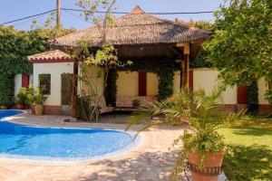 a house with a swimming pool and a gazebo at Andalusian Villa w/ Pool, Garden & Barbecue in Écija