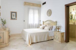 a white bedroom with a bed and a mirror at Andalusian Villa w/ Pool, Garden & Barbecue in Écija