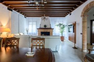 Una sala de estar con un sofá y una chimenea. en Andalusian Villa w/ Pool, Garden & Barbecue, en Écija
