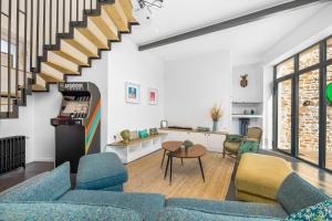 una sala de estar con sofás azules y una escalera. en la Zinguerie de la Plage - plage 300m, babyfoot, arcade, familial et design, en Saint-Pair-sur-Mer
