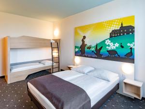 ein Schlafzimmer mit einem Bett und einem großen Wandgemälde in der Unterkunft B&B Hotel Göttingen-City in Göttingen