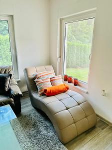 un divano in pelle in un soggiorno con finestra di Vikendica Gracanica 