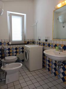 La salle de bains est pourvue d'un lave-linge et d'un lavabo. dans l'établissement CasaFrancesca Calasetta, à Calasetta