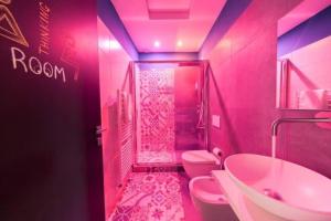 a pink bathroom with a shower and a toilet and a sink at CA’ De La Torre in Bologna