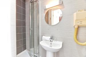 a bathroom with a sink and a shower and a mirror at Properties Unique Dene Rooms - Double Room in Newcastle upon Tyne