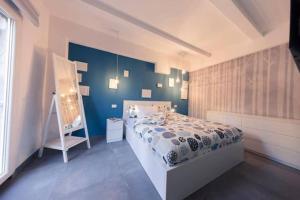 - une chambre avec un lit et un mur bleu dans l'établissement CA’ De La Torre, à Bologne