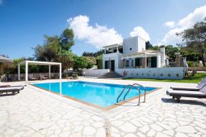 a villa with a swimming pool and a house at Beachfront Villa Victoras - With private beach in Sidari