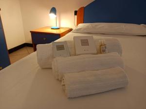 un lit avec des serviettes et une table avec une lampe dans l'établissement CasaFrancesca Calasetta, à Calasetta