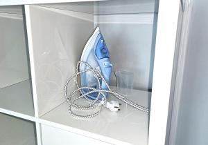 a blue hairdryer and a chain in a cabinet at Pięćdziesiątka in Płock