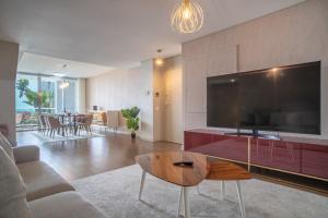 uma sala de estar com uma grande televisão de ecrã plano em Madeira Residence Apartment AK5 no Funchal