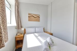 Un dormitorio con una cama blanca con toallas. en Properties Unique Dene Rooms - Double Room, en Newcastle