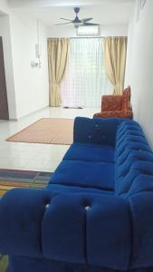 HOMESTAY BUDGET MASJID TANAH PERDANA في مسجد طنة: أريكة زرقاء في غرفة المعيشة مع كرسي