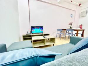 uma sala de estar com duas cadeiras azuis e uma televisão em G5 1-8Pax Cozy 2Room Sunway Medical 3Q beds TV WIFI em Kampong Penaga