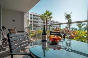 uma mesa de vidro com uma garrafa de vinho e uma taça de fruta em Madeira Residence Apartment AK5 no Funchal
