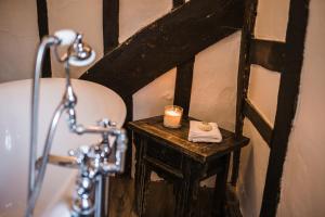 a bathroom with a shower and a table with a candle at Taylour House - Edenbridge in Kent