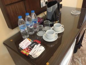 a table with two cups and water bottles on it at Karam Inn in Aqaba