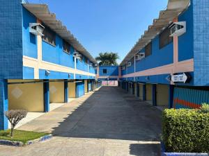 a long corridor of a blue building with a sidewalk at Apice Motel Itu (adults only) in Itu