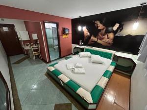 a bedroom with a large bed with a picture on the wall at Apice Motel Itu (adults only) in Itu