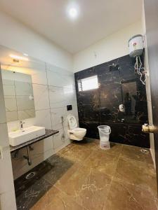 a bathroom with a toilet and a sink at New Royal Orbit Hotel and Restaurant in Dabok