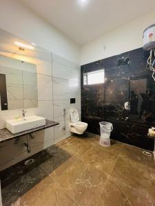 a bathroom with a sink and a toilet and a mirror at New Royal Orbit Hotel and Restaurant in Dabok
