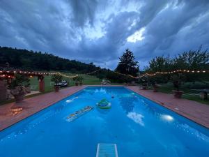 a large blue swimming pool with christmas lights at Cavallina Retreat in Rivoli Veronese