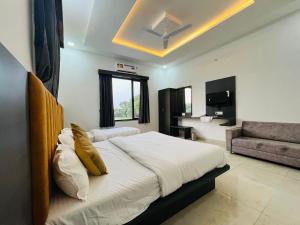 a bedroom with a large bed and a couch at New Royal Orbit Hotel and Restaurant in Dabok