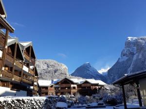 eine Ski-Lodge mit schneebedeckten Bergen im Hintergrund in der Unterkunft Studio Samoëns, 1 pièce, 4 personnes - FR-1-624-115 in Samoëns