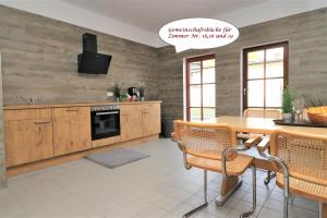uma cozinha com armários de madeira e uma mesa com cadeiras em Ferienzimmeranlage Deutsches Haus Deutsches Haus App 18 em Wustrow