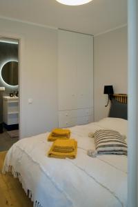 a white bed with two towels on top of it at Seaside apartment Albatross, 16 in Ķesterciems