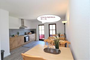 eine Küche und ein Esszimmer mit einem Tisch und Stühlen in der Unterkunft Ferienzimmeranlage Deutsches Haus Deutsches Haus App 25 in Wustrow