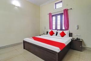 a bedroom with a large bed with red pillows at Balindira Guest House in Dehradun