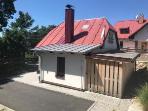 un pequeño cobertizo con techo rojo en una casa en Malá Kráska, en Nicov