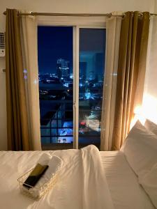una camera da letto con un letto e una finestra con vista di 11F Condo at The Loop Tower Limketkai Center CDO a Cagayan de Oro