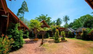 una casa con un patio con árboles y plantas en O k Chawkoh Bungalow, en Ko Lanta